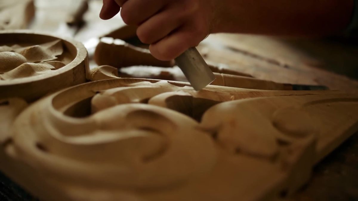 Woodcarver carving an ornament with a mallet and gouge (symbolic image)