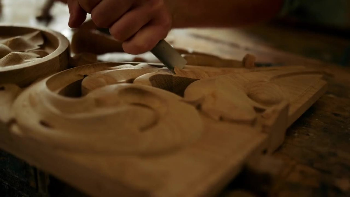 Sculpteur sur bois ciselant un ornement avec un maillet et une gouge (image symbolique)
